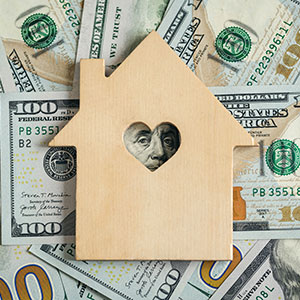 Get up to $6,000 for Down Payment Assistance photo of money and wooden house cutout